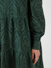 Dark green cotton dress featuring intricate broderie anglaise patterns, long sleeves with elastic cuffs, and a tiered skirt design.