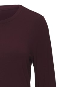 Burgundi pikkade varrukatega pluus ümmarguse kaelusega, valmistatud pehmest, venivast kangast. Sile tekstuur ilma mustrite või lisadeteta.