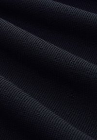 Zwart ribbelstof met een gemêleerd patroon, die diepgroene tonen toont en een zachte, flexibele val heeft. Ideaal voor casual kleding of als laagje.