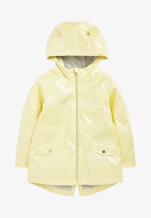 Impermeabile per bambini giallo pallido con cappuccio, cerniera frontale, due tasche con pattina e bottoni a pressione, e orlo posteriore leggermente più lungo.