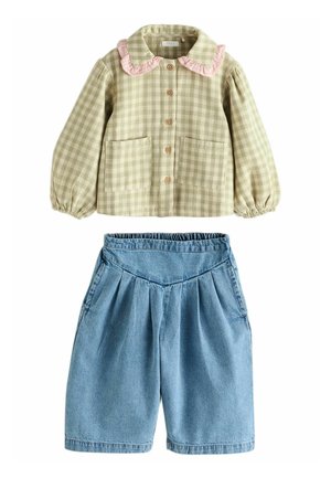 Chemise à carreaux vichy verte avec un col volanté rose et deux poches, associée à un short en denim plissé bleu.