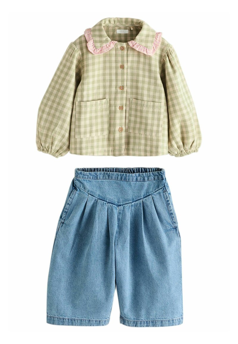 Chemise à carreaux vichy verte avec un col volanté rose et deux poches, associée à un short en denim plissé bleu.