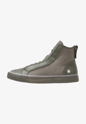 High-top sneakers in olive green fabric and leather. Textured accents, rubber sole, padded collar, and logo on the heel.