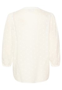 Blusa blanca ligera con mangas largas abullonadas, texturizada con pequeños puntos blancos en relieve y un escote redondeado. Tela suave y fluida.
