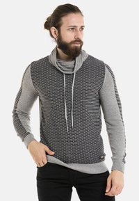 Grau und schwarz gemusterter Pullover mit einem Schalkragen, langen Ärmeln und Kordelzugdetails; mit gerippten Bündchen und Saum.