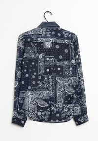 Camisa azul marino de botones con patrones de paisley blancos, que presenta un cuello clásico y mangas largas, confeccionada en una tela suave.