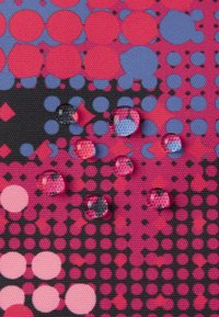 Teksturowana tkanina z wzorem różowych, fioletowych i czarnych kół oraz kropek, z kroplami wody na powierzchni.