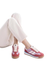 Zapatillas deportivas en rosa, morado y blanco. Materiales de ante y malla. Presentan rayas blancas, cordones redondos y suelas de goma texturizadas.