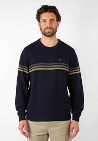Pull en tricot bleu marine avec un col rond, orné de rayures horizontales grises et vertes. Les poignets et l'ourlet côtelés ajoutent de la texture.