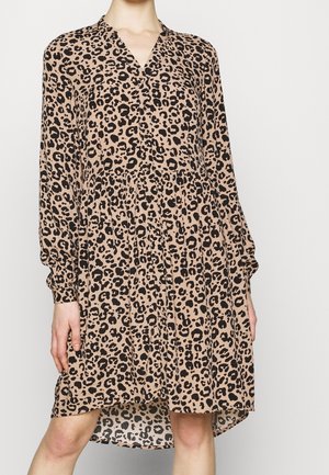 Robe imprimée léopard en beige et noir, avec des manches longues, un col en V et une jupe à volants avec un ourlet asymétrique. Tissu doux et léger.