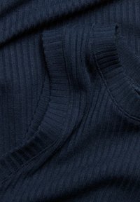 Navy-blaues Rippenstrickgewebe mit glatter Textur und horizontalen Linien, ausgestattet mit einem Rundhalsausschnitt und enganliegenden Ärmeln. Das Detail betont die Weichheit.