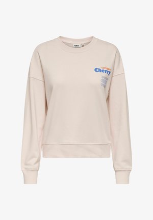 Jasnoróżowa bluzka z długim rękawem, okrągłym dekoltem i skróconym fasonem. Posiada niebieską grafikę "Cherry" oraz szczegóły z etykietą z organicznej bawełny.