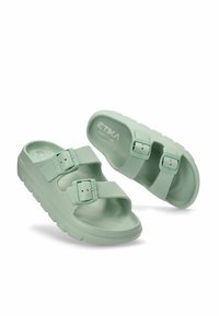 Sandalias de slider color verde menta hechas de goma suave, con dos hebillas ajustables y una plantilla con contorno. Suela texturizada para mayor agarre.