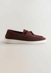 Des chaussures à enfiler en suède bordeaux avec des détails tissés sur les côtés, un bout rond et une semelle en caoutchouc blanche. Elles présentent un design plat et n'ont pas de matériel visible.