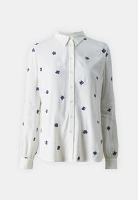 Camicia bianca con maniche lunghe, chiusura frontale a bottoni e ricamo floreale blu. Caratterizzata da un colletto classico e polsini delle maniche arricciati.