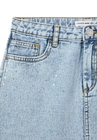 Shorts di denim azzurro chiaro con un leggero effetto acid wash, impreziositi da strass argento disposti in un motivo sparso.