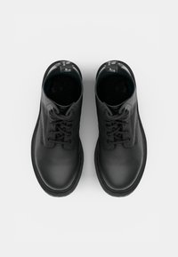 Botas de tobillo de cuero negro con puntas redondeadas, que presentan cordones negros, paneles texturizados y un acabado suave. Las suelas negras mate completan el diseño.