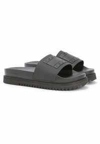 Black slide sandals featuring a textured strap with raised logo accents, a thick textured sole, and a contoured footbed for support.