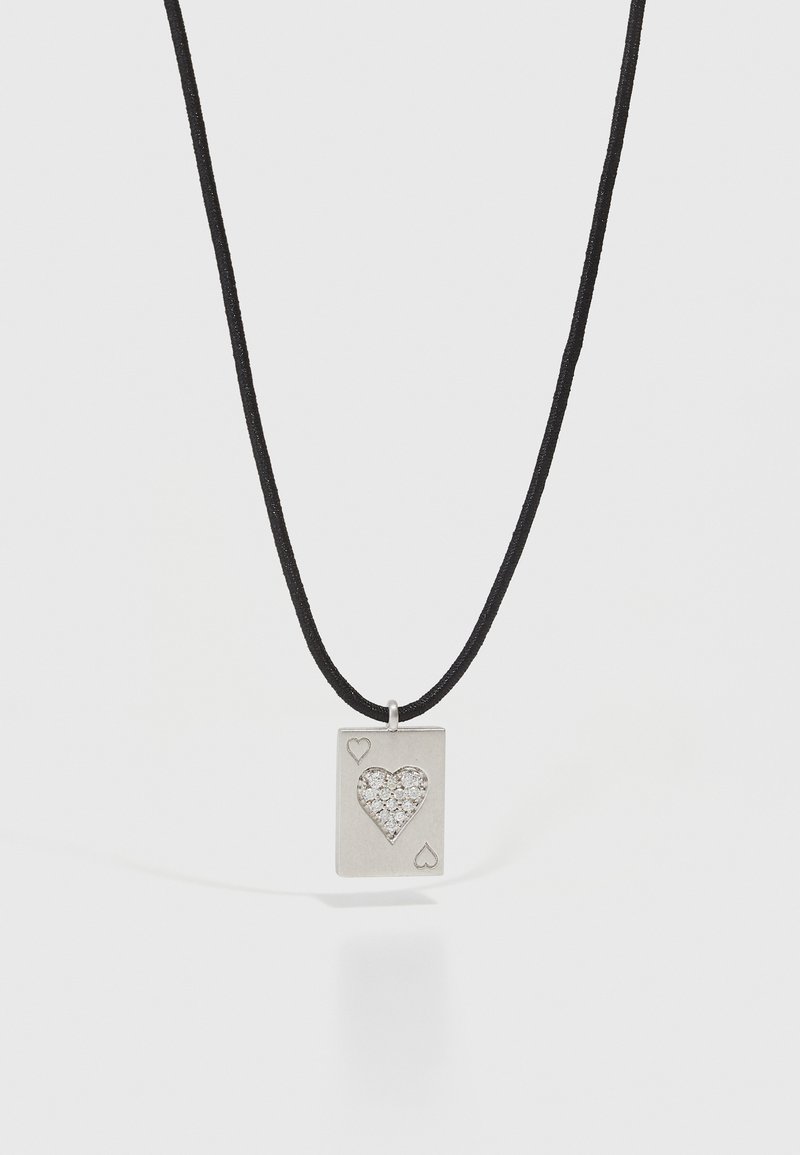 Sølv rektangulært vedhæng med et hjerteudskæring, prydet med små sten, der er fastgjort til en sort snorhalskæde. Hjerte mønstre på siderne.