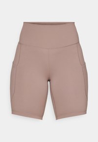 Shorts de cycliste taille haute mauve avec poches latérales et coutures apparentes, fabriqués en tissu lisse et élastique.