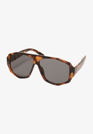 Gafas de sol octogonales con una montura de carey oscuro, lentes grises y patillas gruesas. Textura suave con acentos en un marrón claro contrastante.