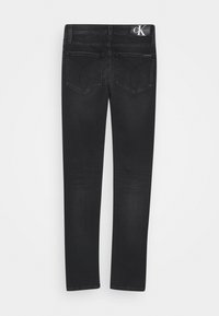 Czarne dżinsy o slim fit z dwoma tylnymi kieszeniami oraz metką logo CK na pasie. Gładka tekstura i prosty krój nogawki.