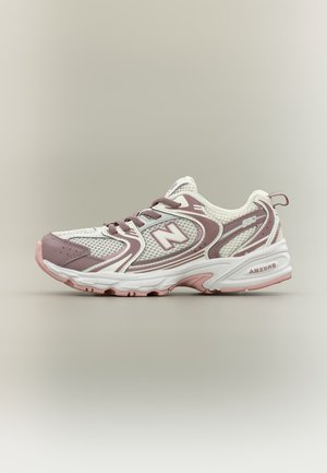 Witte en mauve New Balance hardloopschoen met meshpanelen, veters en een gedempte zool met ABZORB-technologie detail.
