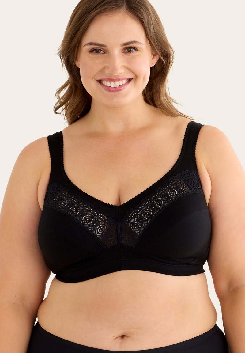 Svart bh med en spetspanel upptill, breda axelremmar och ett slätt, matt tyg. V-ringning som framhäver formen.