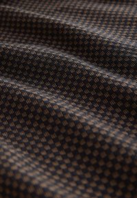 Textured fabric featuring a dark navy background with a small, repeating beige checkered pattern. The surface appears soft with a slight sheen.