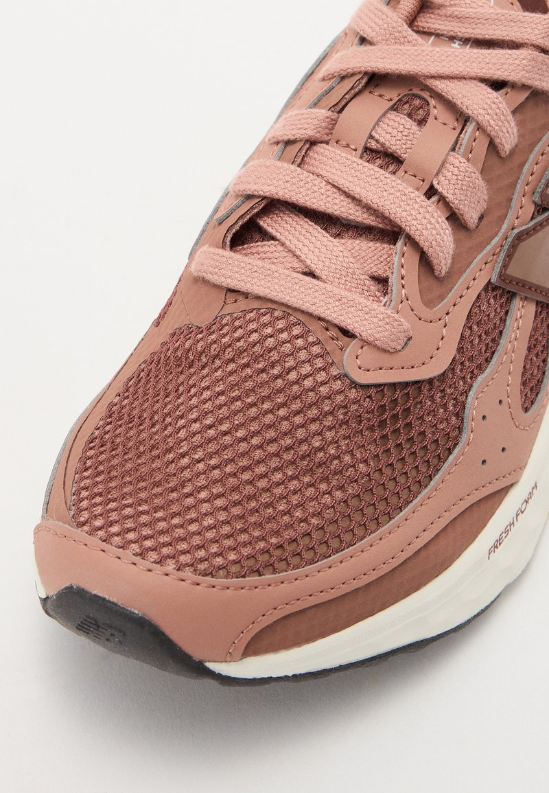 Braune Mesh-Sneaker mit rosa Lederakzenten, sechseckigem Muster im Obermaterial, flachen Schnürsenkeln, gepolsterter Sohle und strukturiertem Gummilaufsohle.
