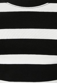 Schwarz-weißer gestreifter Stoff mit abwechselnd horizontalen Streifen; die Textur wirkt gerippt; runder Halsausschnitt mit sichtbaren Nähten.