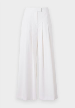 Baltas platajās biksēs ar krokām, izgatavotas no gludas auduma. Piedāvā augstu jostasvietu un pielāgotu griezumu, nodrošinot strukturētu izskatu.