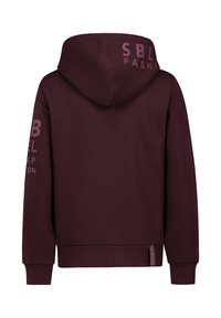 Burgundy hoodie with a large hood, front kangaroo pocket, and text accents on the right sleeve and back. Soft, textured fabric.