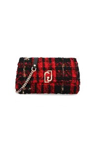 Bolso de mano de tela de cuadros rojo y negro tejido, con un logo dorado, acentos de cuero negro y una correa de cadena plateada. Detalle de superficie texturizada.