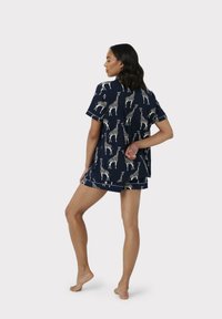Conjunto de pijama de manga corta en azul marino con estampado de jirafas, con una parte superior de corte holgado y pantalones cortos a juego, fabricado en tejido suave.