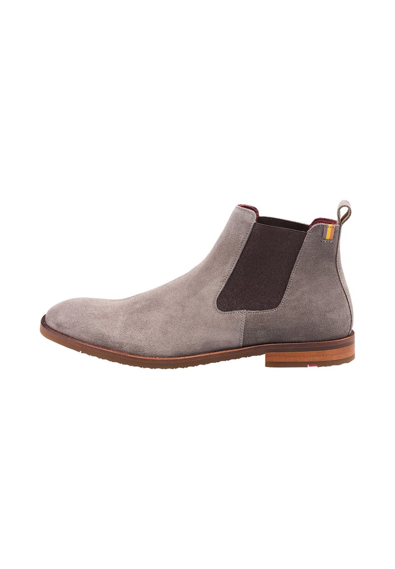 Stivale alla caviglia in suede grigio con pannelli laterali elastici, dettagli marroni e tacco in legno marrone. Superficie strutturata e costruzione robusta.