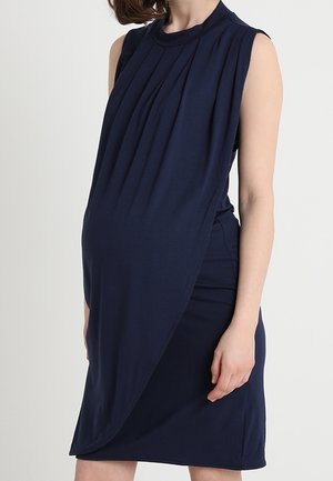 Robe sans manches bleu marine avec devant plissé et drapé asymétrique, fabriquée en tissu doux, conçue pour les vêtements de maternité.