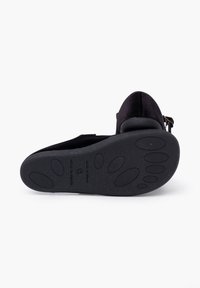Schwarzer Wildlederschuh mit runder Spitze und flexibler Gummisohle, die über einen kleinen Absatz und runde, strukturierte Griffdetails auf der Sohle verfügt.