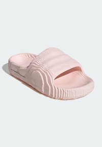 Rosa halksandaler gjorda av texturerad gummi, med ett brett band och öppen tå-design samt ribbad detaljer längs sidorna och botten.