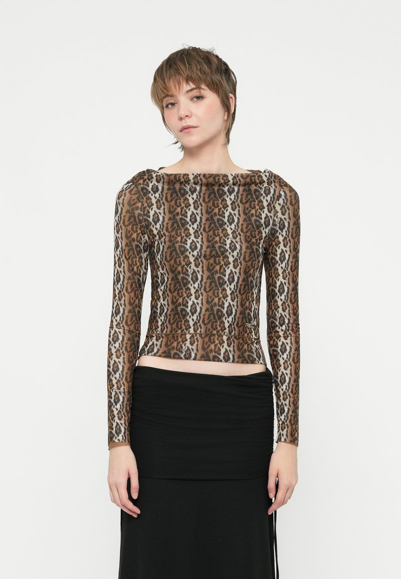 Camisola de mangas compridas com estampa de leopardo, com decote barco e design ajustado, feita de um tecido liso e elástico; combinada com uma saia preta.