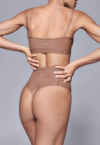 Set di reggiseno seamless marrone e mutande a vita alta con spalline sottili, texture morbida e fascia elastica con il logo "ITEM m6."