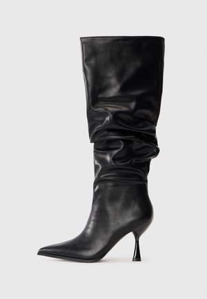 Zwarte leren kniehoog laars met een slouchy ontwerp, spitse neus en een dunne stilettohak, met een gladde textuur en minimale accenten.