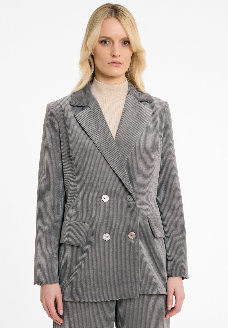 Grijze corduroy dubbelzijdige blazer met notch-lapel, twee voorkruiden en ronde knopen. Verticale ribbeltextuur overal.
