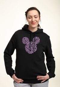 Felpa nera con una grande silhouette di Topolino in stampa animale viola. Il tessuto sembra morbido, con una vestibilità standard e un cappuccio regolabile con cordino.