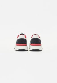 Sneaker da uomo con una tomaia in tessuto nero e blu navy, dettagli rossi e una suola bianca imbottita. Presenta una punta rotonda e lacci piatti.