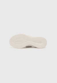 Shoe sole featuring a textured rubber surface with a wave pattern, predominantly beige with subtle contouring for grip and flexibility.