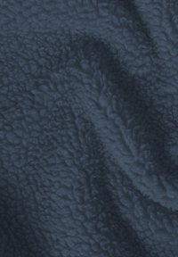Tissu en polaire bleu marine avec une texture douce et bouclée, présentant des coutures visibles montrant les plis de ce matériau épais et chaud.