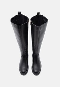 Μαύρες δερμάτινες μπότες μέχρι το γόνατο με λεία υφή, διαθέτοντας φερμουάρ στο πλάι και θηλιές στο πάνω μέρος για εύκολη εφαρμογή.