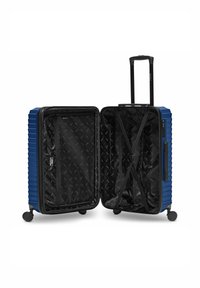 Valise rigide bleue avec quatre roues et poignée extensible, ouverte pour dévoiler un intérieur noir avec une poche en maille, des sangles de compression et un revêtement doux.
