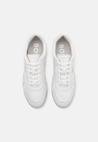 Hvite lær sneakers med en jevn tekstur, perforert tå, flate lisser og diskret merking på sidene og innersålene. Minimalistisk design.